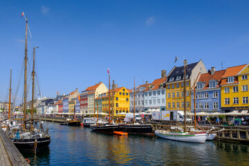 Denmark, Copenhagen, Boats moored along Nyhavn canal with colorful townhouses in background