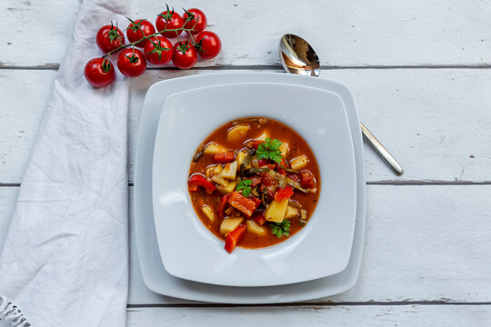 Plate of vegan goulash with&Ocirc;&oslash;&Omega;potatoes, bell pepper, tomatoes, leek and parsley