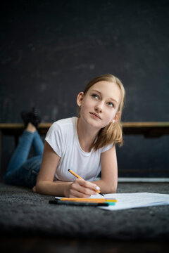 Girl lying on carpet and learning at home