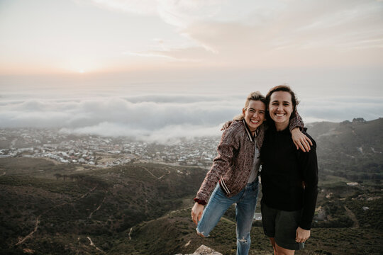 South Africa, Cape Town, Kloof Nek, portrait of two happy women embracing at sunset