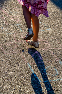 Girl playing hopscotch, partial view