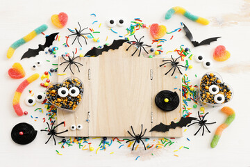 holidays image of Halloween. spiders, bats and wooden board frame for text or mock up over white wooden table