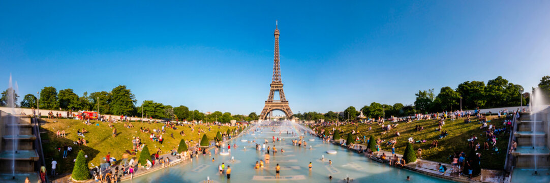 Panoramic view of Eiffel Tower and people cooling off in Trocadero fountain, Paris, France