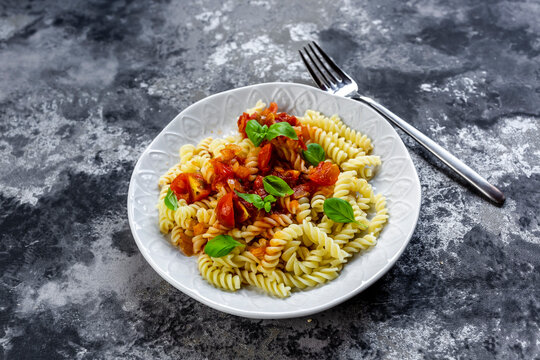 Plate of vegan pasta with tomatoes and basil