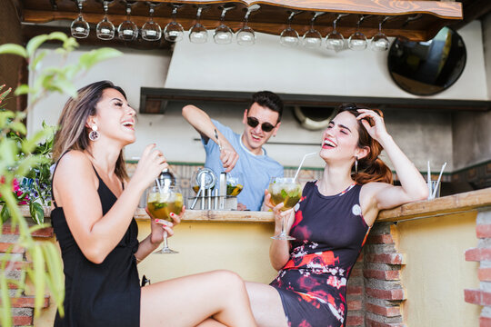 Two happy women having a drink at a bar