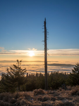 Sun setting over foggy landscape seen from summit of Heugstatt mountain