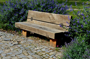 Park resting place with benches made of solid wood connected to a wooden log house pins. The...
