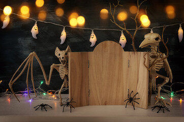 holidays image of Halloween. spiders, skeletons and wooden board frame for text or mock up over table