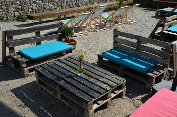 benches and seats, beach-type fabric chairs. tables where it is possible to have coffee on the sun. soft colored postmen soften sitting on pallets made by self-help