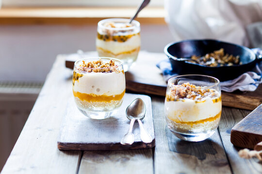 Unbaked cheesecake in a glass with passion fruit and nut brittle