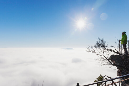 Germany, Rhineland-Palatinate, Hiker admiring Palatinate Forest shrouded in thick clouds