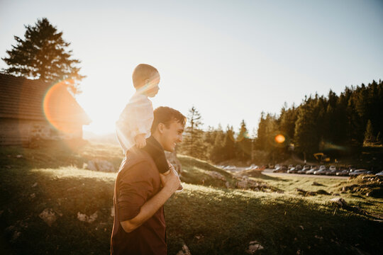 Father carrying little son on shoulders on a hiking trip at sunset, Schwaegalp, Nesslau, Switzerland