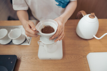 Female hands holding cup of coffee with paper filter