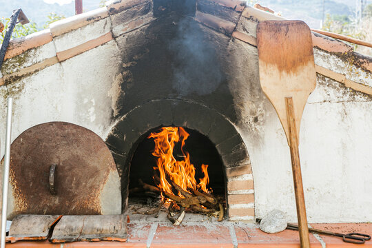 Wooden pizza peel by wood burning stove