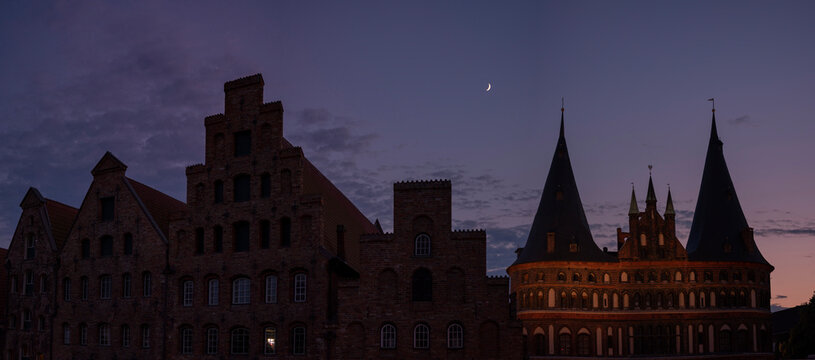Germany, Schleswig-Holstein, Lubeck, Salzspeicher warehouses and Holsten Gate at night