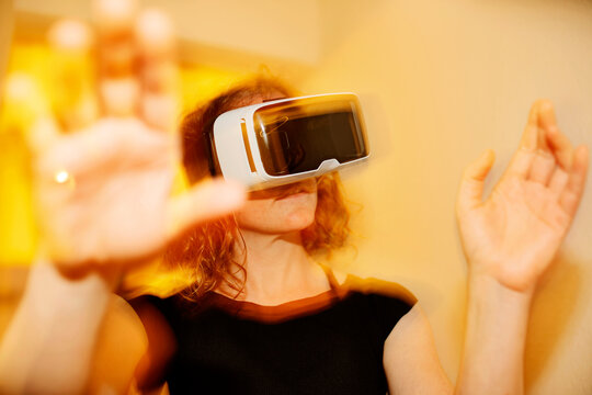 Close-up of mid adult woman looking through virtual reality simulator at home