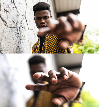 Man stretching hand while standing by wall