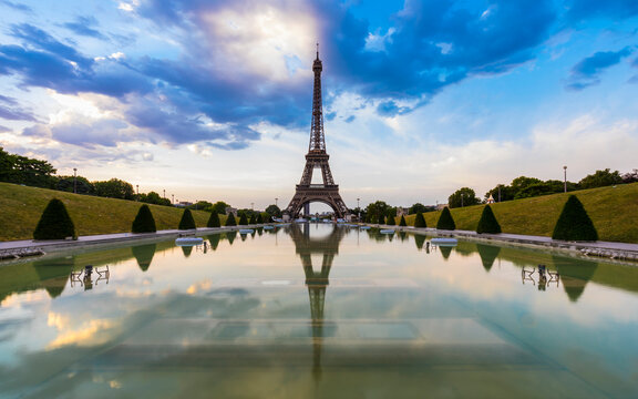 Eiffel Tower by Seine river against blue sky at sunset, Paris, France
