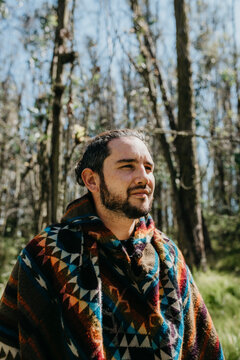 Man wearing traditional Andean poncho while standing outdoors