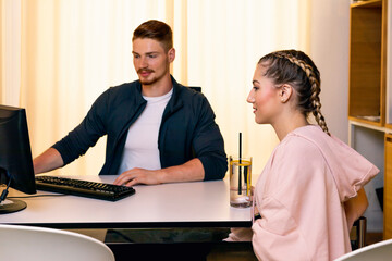 Young woman talking to employee at desk in a gym