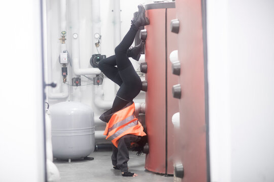 Technician doing a handstand in the boiler room