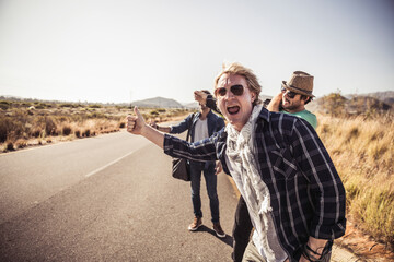Three men hitchhiking at a country road