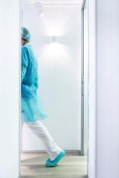 Mature male dentist walking in illuminated hallway