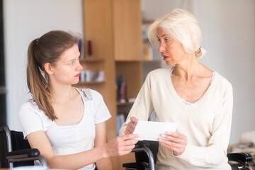 Mother and daughter in a wheelchair with a letter