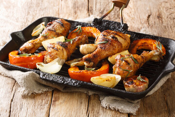 Homemade grilled chicken legs with pumpkin close-up in a grill pan on the table. horizontal