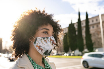 Afro woman with protective face mask in city during COVID-19