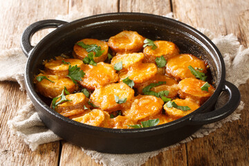 Closeup of cooked Spanish potatoes in a spicy sauce Patatas a la importancia in a frying pan on the...