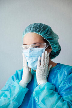 Mature female doctor wearing protective face mask with scrubs at clinic