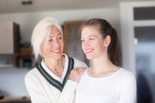 Portrait of smiling mature woman watching her adult daughter