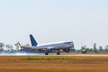 Passenger plane taking off from runway at airport on sunny day.