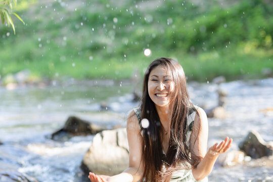 Young woman splashing in a river