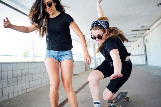 Young woman skateboarding in underpass