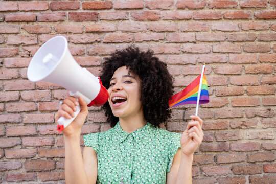 Mixed race woman protesting for LGBTQI rights against brick wall