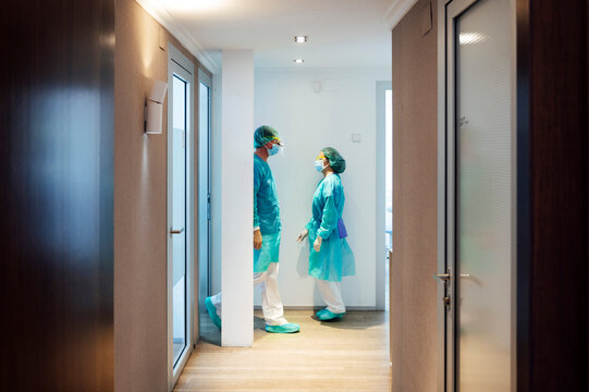 Male and female dentists walking in hallway at clinic