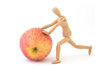 wooden man model rolling red apple