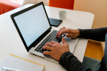 Man using laptop at table in living room