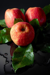 Fresh apples with drops of water on a black background.