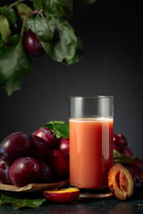 Plum juice and fresh purple plums.