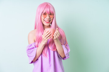 Young Asian woman with pink hair posing on green background