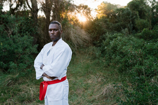 Portrait of martial artist standing outdoors with crossed arms