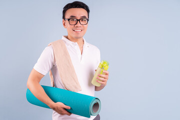 Asian man wearing sportswear and holding water bottle, gym and yoga concept