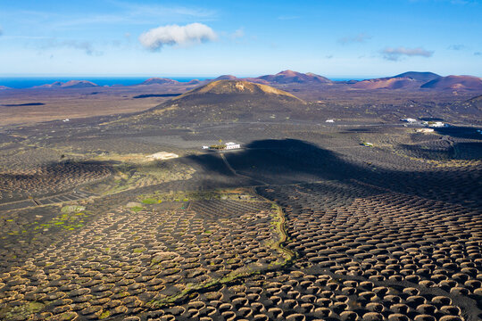 Spain, Canary Islands, Lanzarote, wine growing area La Geria at Yaiza, in the back the volcanos, aerial view