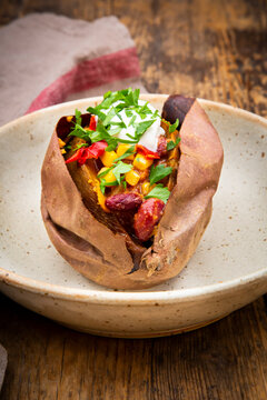 Sweet potato kumpir with chili con carne, sour cream and coriander