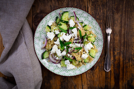 Plate of vegetarian salad with cucumbers, quinoa, feta cheese, red onions and mint