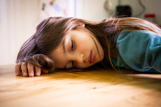 Bored girl lying on kitchen table