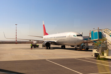 Fototapeta na wymiar Airplane is parked near gate of airport terminal